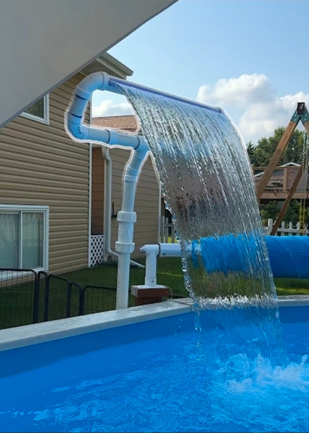 Custom PVC waterfall fountain built from return-line plumbing on a pool